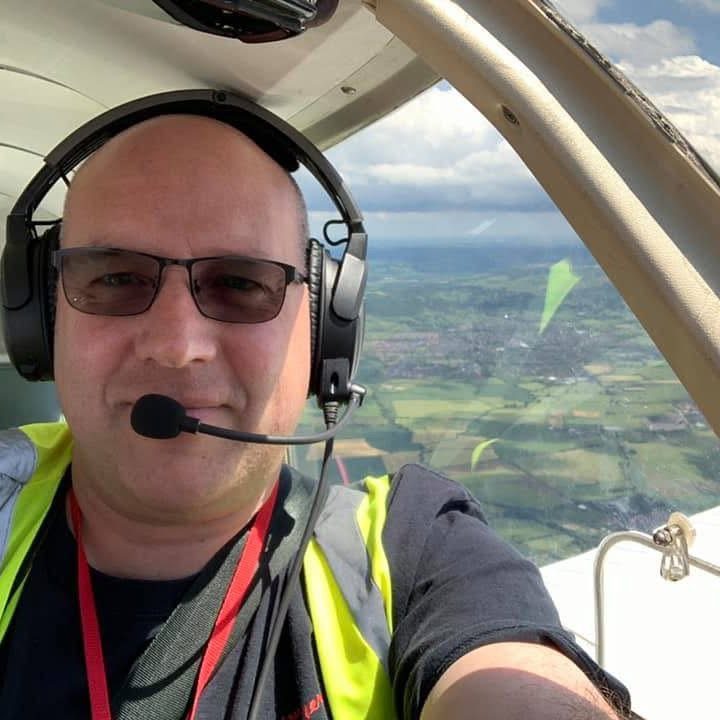 Paul Fearn, aviation photographer, airborne in a light aircraft wearing a flying headset above the English countryside