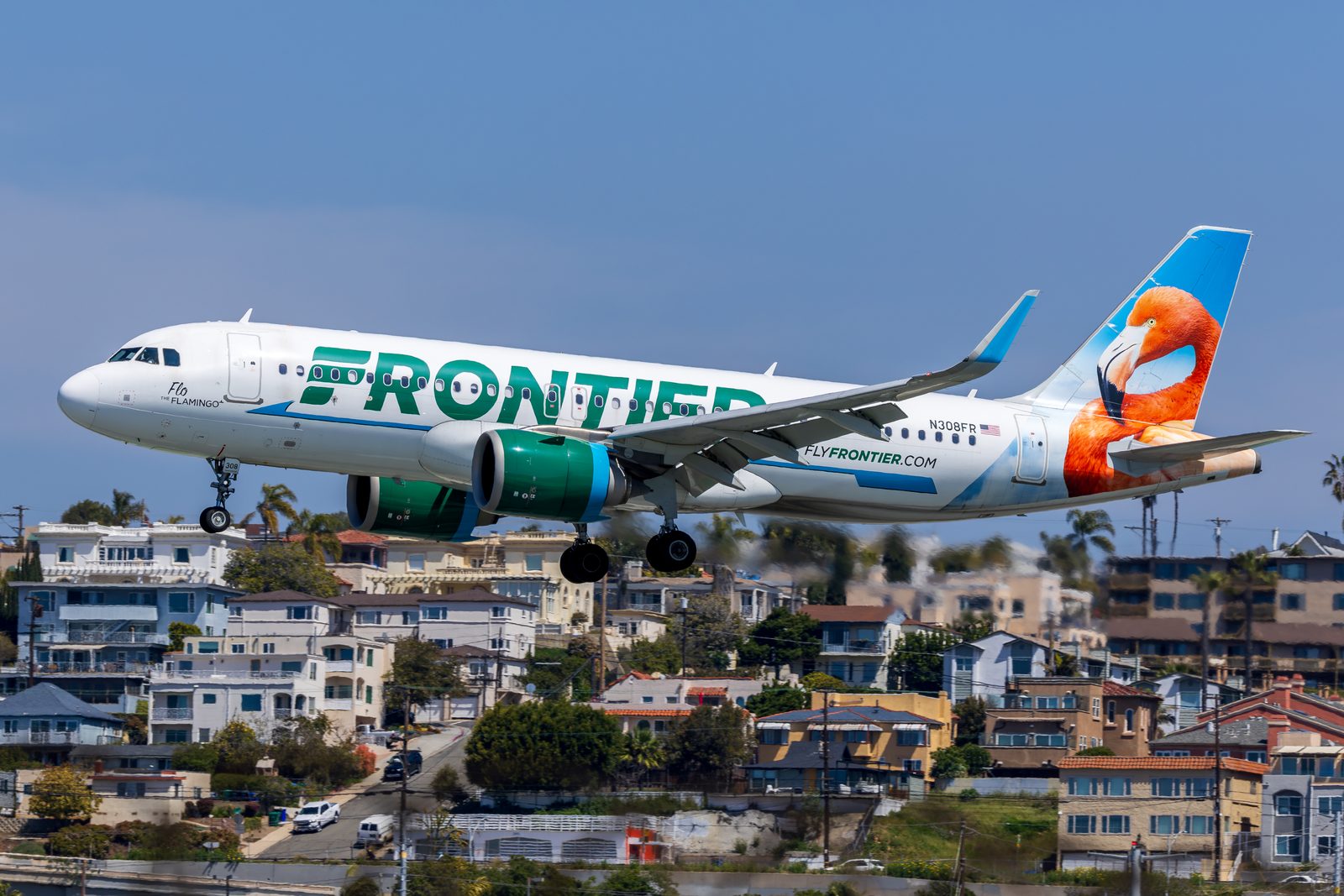 Frontier Airlines Airbus A320neo descending over houses on approach to San Diego.