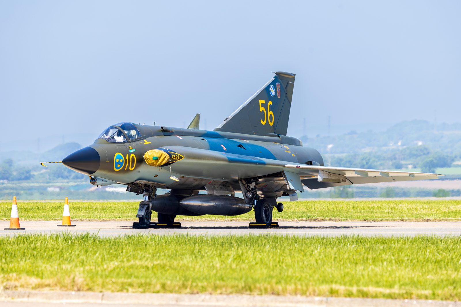 Saab J-35J Draken in Swedish camouflage marked 56 on the ground with the runway behind.